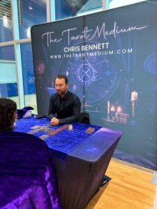 The Tarot Medium Chris Bennett reading at a psychic fair, where transformative readings go beyond the spread