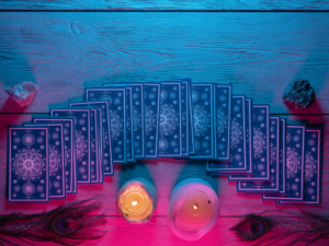 Tarot cards fanned face down on a table beside a candle, ready for a synchronistic draw