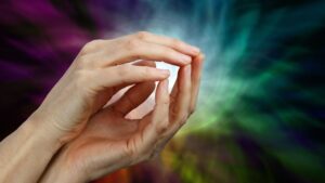 Healing hands with psychic and spiritual energy emanating in a rainbow aura