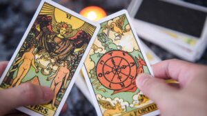 Rider-Waite tarot cards with a hand holding The Lovers and Wheel of Fortune