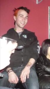 Chris Bennett as a punk kid in 2003 with an orange and black mohawk, years before the tarot table