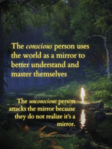 An illuminated human silhouette standing beside a river at night, reflected imperfectly in rippling water at the edge of a forest. The image includes the quote: “The conscious person uses the world as a mirror. The unconscious person attacks the reflection.”